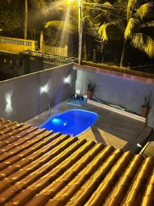 a swimming pool in a backyard with a table and chairs at Refúgio do Mar in Ilhéus