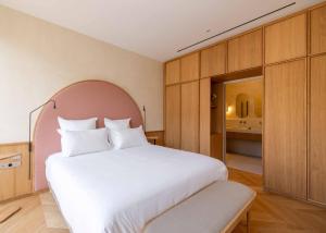 a bedroom with a large white bed and a bathroom at Boutique-Hôtel Le N3 par Champagne Thiénot in Reims