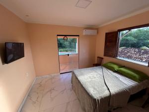 a bedroom with a bed and a large window at Refúgio do Mar in Ilhéus +41 photos