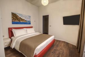 a bedroom with a bed and a flat screen tv at Le Due Piazze in Genoa
