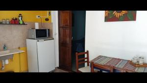 a kitchen with a refrigerator and a table and a microwave at Glamaué 2 in Carhué