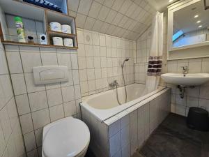 a bathroom with a toilet and a tub and a sink at Gepflegte Monteurswohnung in Rommerskirchen in Rommerskirchen