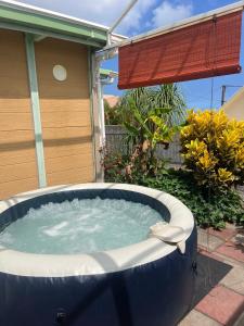 a large jacuzzi tub in front of a house at Bungalow & Jacuzzi 24h24 7j7 in Petite Île