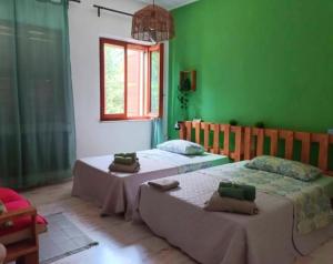 two beds in a room with green walls at Affittacamere Osimo Rose in Osimo