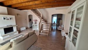 a living room with a couch and a staircase at Villa Elisa in Saluzzo