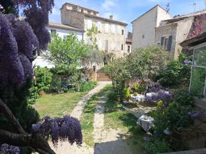 a garden with purple flowers and a building at La Maison du Chichui in Orgon