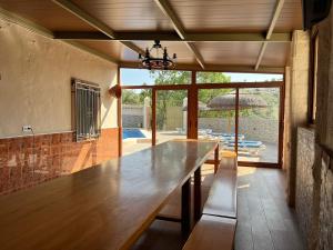 a large wooden table in a room with a patio at Cortijo rural Los Pinos in Villanueva de Algaidas