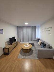 a living room with a couch and a table at Art House Madeira II in Caniço