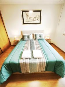 a bedroom with a large bed with two towels on it at Art House Madeira II in Caniço