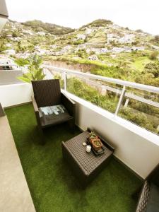 a balcony with a table and a chair and a view at Art House Madeira II in Caniço
