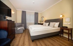 a hotel room with a bed and a chair at Hotel Altmünchen by Blattl in Munich +98 photos