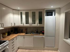 a kitchen with white cabinets and a refrigerator at Gullvikvegen 33 in Namsos