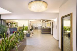 an open hallway with plants and a large chandelier at Best Western City Hotel in Bologna