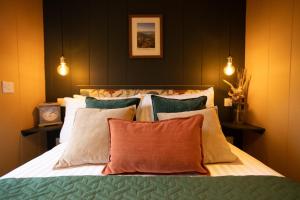 a bedroom with a large bed with many pillows at Wigtown by Wigwam Holidays in Newton Stewart