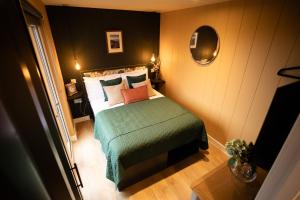 a small bedroom with a bed and a mirror at Wigtown by Wigwam Holidays in Newton Stewart