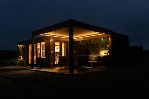 a pavilion with a table and chairs at night at Wigtown by Wigwam Holidays in Newton Stewart