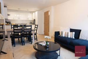 a living room with a blue couch and a table at Hook Three Bed Flat Parking in Hook