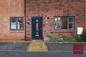a brick building with a blue door and two windows at Hook Three Bed Flat Parking in Hook