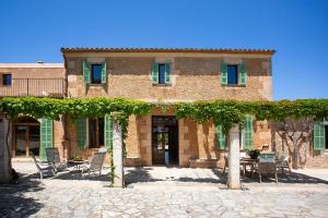 a brick building with chairs and a table in front of it at Agroturisme Vistalegre Nou in Manacor
