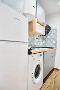 a kitchen with a washer and dryer next to a refrigerator at La Maestra Catedral 1 in Jaén