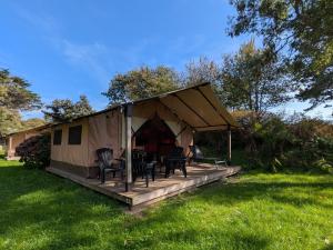 a tent with chairs and tables in a yard at Camping Naéco Audierne in Plouhinec +57 photos