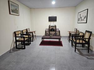 a room with chairs and a table and a tv at Honey Beach House in La Esmeralda