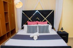 a bedroom with a large bed with red and white pillows at Mystic cabins in Nyeri