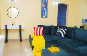 a living room with a blue couch with a yellow blanket at Mystic cabins in Nyeri