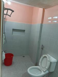 a bathroom with a toilet and a red trash can at cavinitan transient house in Virac