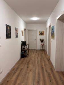 an empty living room with white walls and wood floors at Colibrì Art B&B in San Martino in Argine