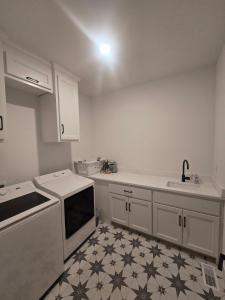 a kitchen with white cabinets and a tile floor at Waterfront Retreat One in Rocky Mount +32 photos