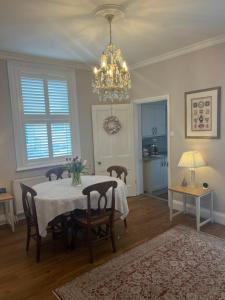a dining room with a table and chairs and a chandelier at The Lily Pad - Boutique Townhouse, a short walk to Town Center and Racecourse in Cheltenham