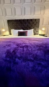 a bedroom with a purple blanket on a bed at The Forest Lodge in Edwinstowe