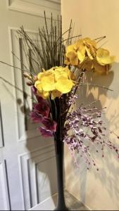 a black vase with yellow flowers in it at The Forest Lodge in Edwinstowe