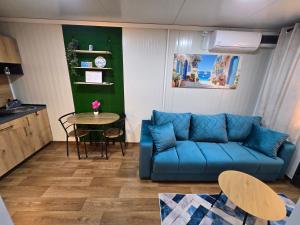 a living room with a blue couch and a table at Moderna smeštaj Kula in Kula