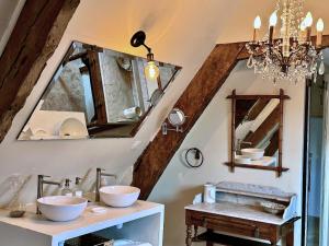 a bathroom with two sinks and a mirror at Manoir du Val Riant in Saint Malo