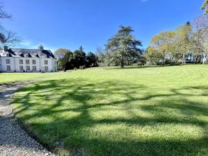 a large grassy field with a large house at Manoir du Val Riant in Saint Malo