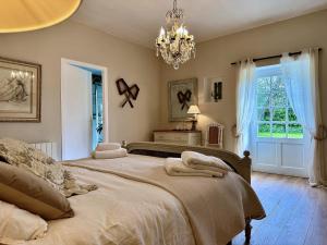 a bedroom with two beds and a chandelier at Manoir du Val Riant in Saint Malo