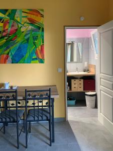 a dining room with a table and a painting on the wall at La Escala in La Celle-sous-Gouzon