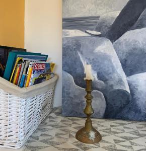 a basket of books and a candle next to a painting at La Escala in La Celle-sous-Gouzon
