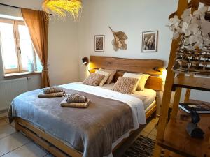 a bedroom with a bed with two towels on it at Penzion PROVANS - Pálava in Dolní Dunajovice