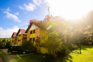 a house with a car parked in front of it at Chalés serra linda in Bananeiras