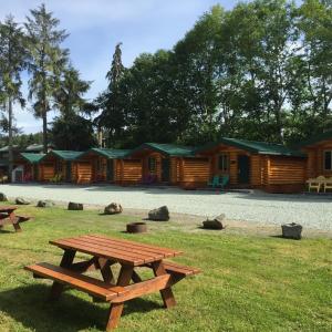 a picnic table in front of a log cabin at Port Hardy Cabins in Port Hardy