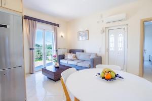 a bedroom with a large bed and a living room at Villa Sofia Almyrida in Almyrida