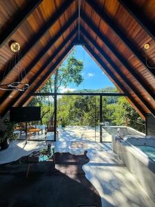 a large room with a large window and a swimming pool at Cabanas do Valle in Itaara