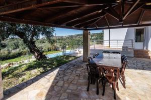 a table and chairs on a patio with a view at Villa Sofia Almyrida in Almyrida