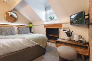 a bedroom with a bed and a tv and a fireplace at Windermere Central Hotel - Central Lake District Hotel in Windermere - Ridgestone in Windermere