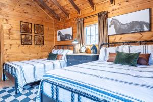 two beds in a room with wooden walls at Northern Acres in Lake George +291 photos