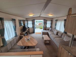 a living room with a couch and a table at Dornoch Holiday Chalet in Proncy