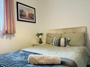 a bedroom with a bed and a picture on the wall at Cosy Flat - Over Arch in Oswaldtwistle